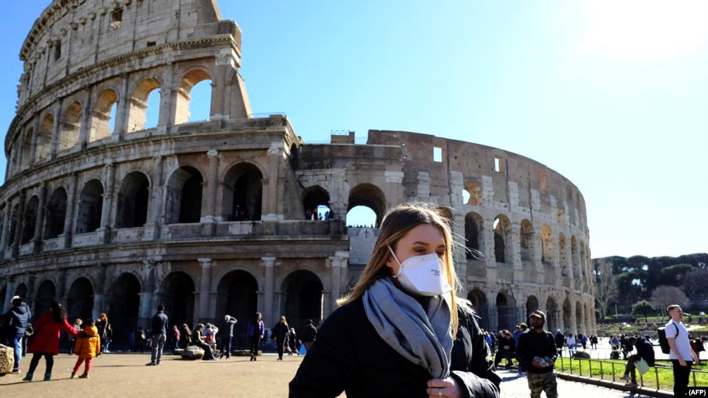 Du khách mang khẩu trang bên ngoài thắng cảnh Colosseo ở Rome ngày 28/2/2020 giữa dịch Covid-19. (Photo by Andreas SOLARO / AFP)