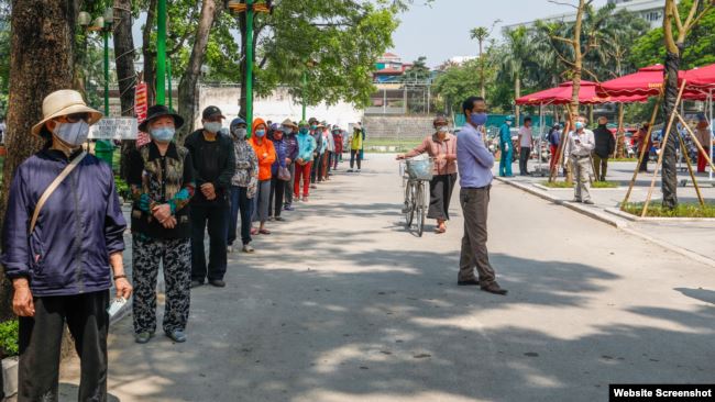 Người dân xếp hàng nhận gạo miễn phí từ máy ATM ở Hà Nội. Photo CAND.